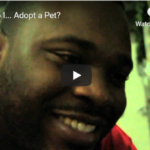 screenshot of a video still with a black man looking down and smiling